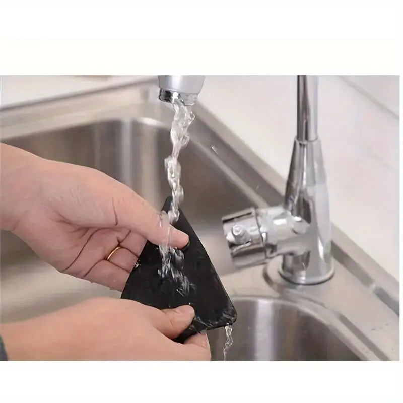 A hand is using a non-slip rug pad gripper to lift and suspend a rug on a tile floor.