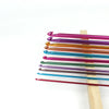 A set of 23 colorful Tunisian crochet hooks with bamboo cables arranged in a row.