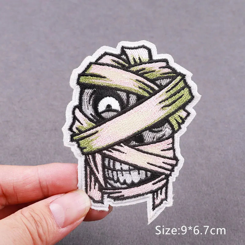 Embroidered skull horror patch featuring a striped bandage design on a light background