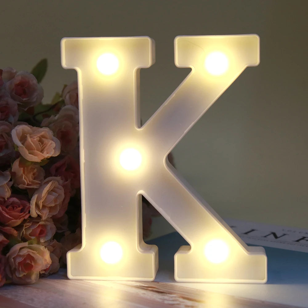 Lettre alphabet K lumineuse LED blanche qui éclaire une surface en bois.