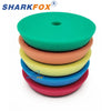 A stack of three green, orange, and yellow car polishing sponge pads for dual-action polishers.