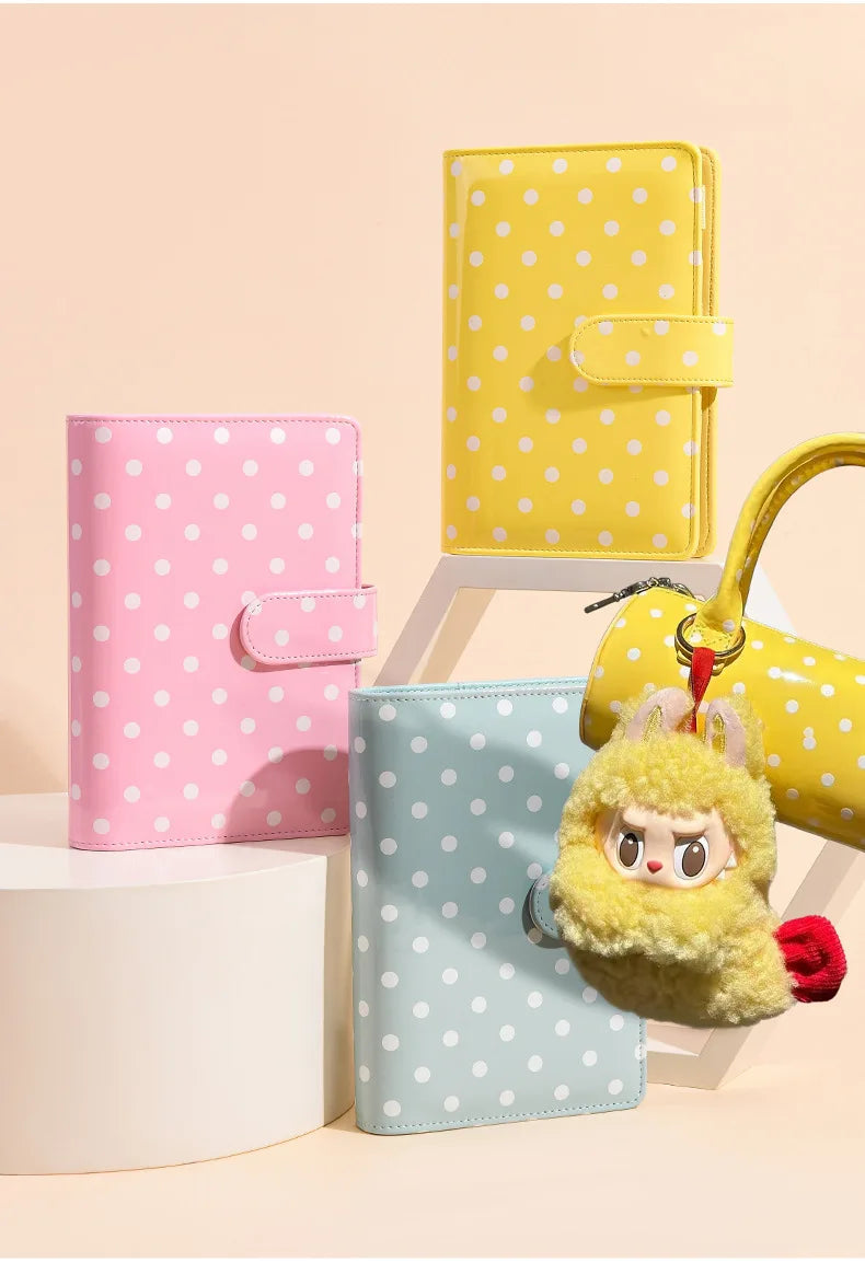 A set of three colorful PU leather binder wallets featuring polka dots and a yellow fluffy keychain.
