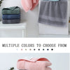 A collection of six folded face towels in various shades of green, blue, and gray are displayed on a white surface.