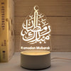 A clear acrylic Ramadan Mubarak night light featuring Arabic calligraphy on a wooden background.