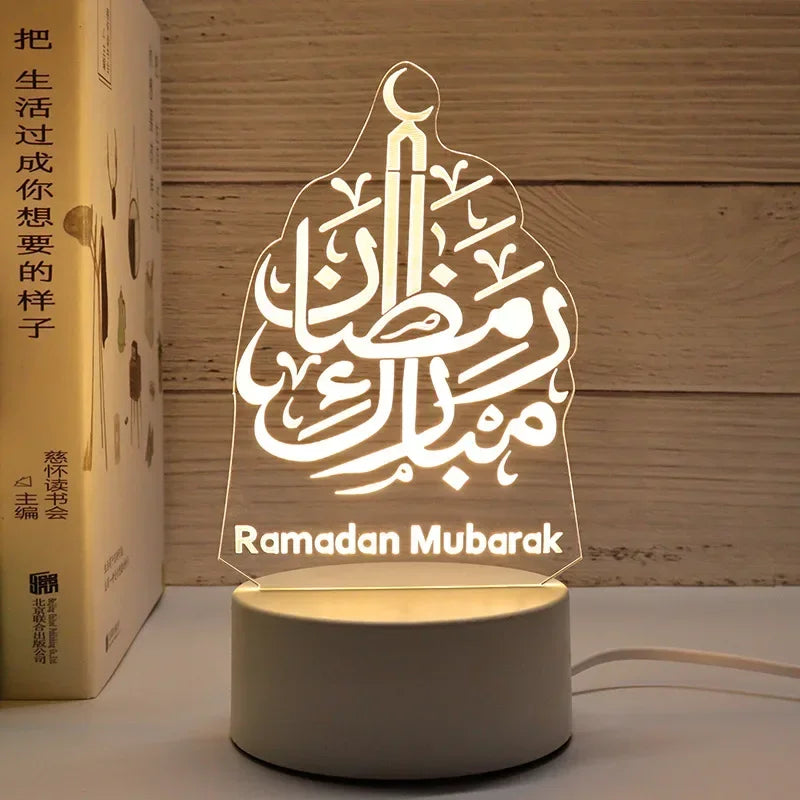 A clear acrylic Ramadan Mubarak night light featuring Arabic calligraphy on a wooden background.