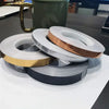 Rolls of self-adhesive waterproof tile gap sealing tape in various colors and a green mug.