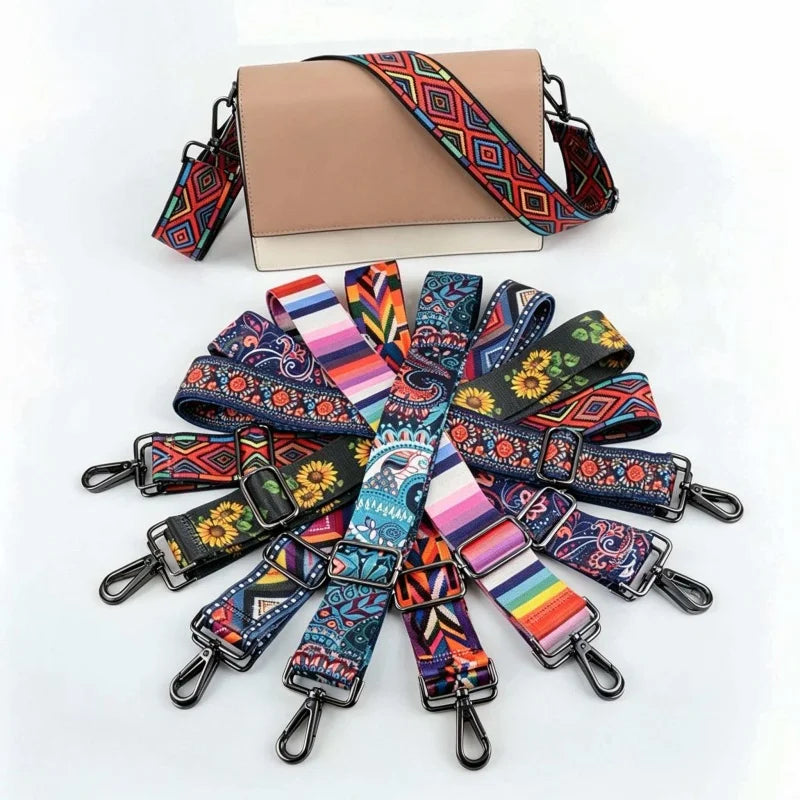 A beige crossbody bag with a patterned strap featuring geometric designs in red, green, and black.
