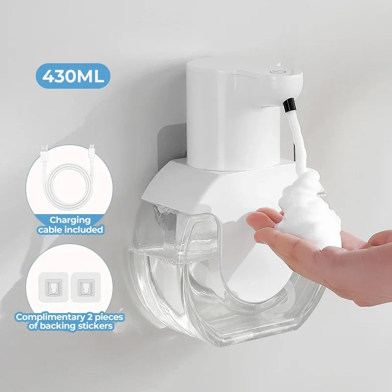 A white wall-mounted infrared automatic foam soap dispenser with a clear reservoir and charging cable included.