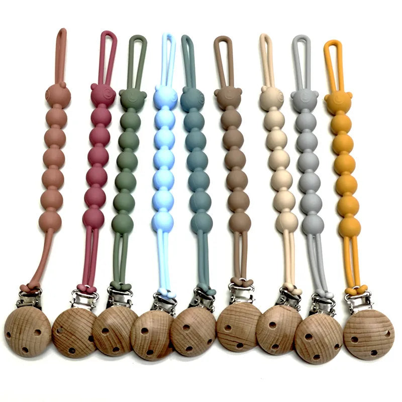 A set of food-grade silicone pacifier clips with anti-lost chains in various pastel colors.