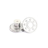 A silver metal button repair kit with five replacement buttons and a flat base.