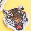 A detailed embroidery patch depicting a tiger's face in black, white, and orange tones.