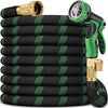 A stack of black garden hoses with green accents and brass nozzles.