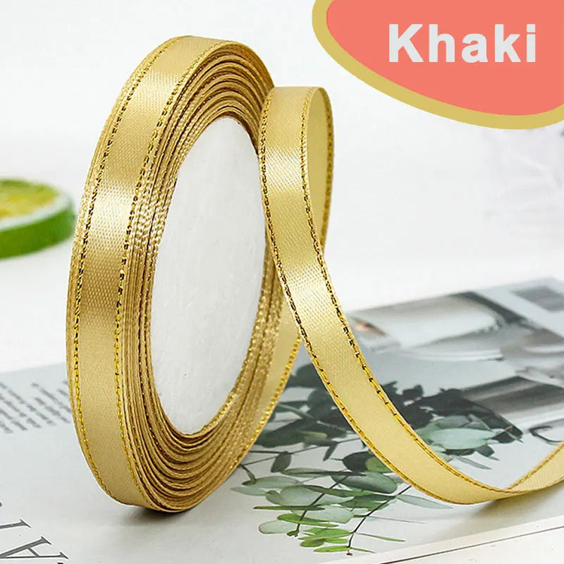 Roll of gold-edge satin ribbon for crafts and decor shown next to a green citrus fruit.