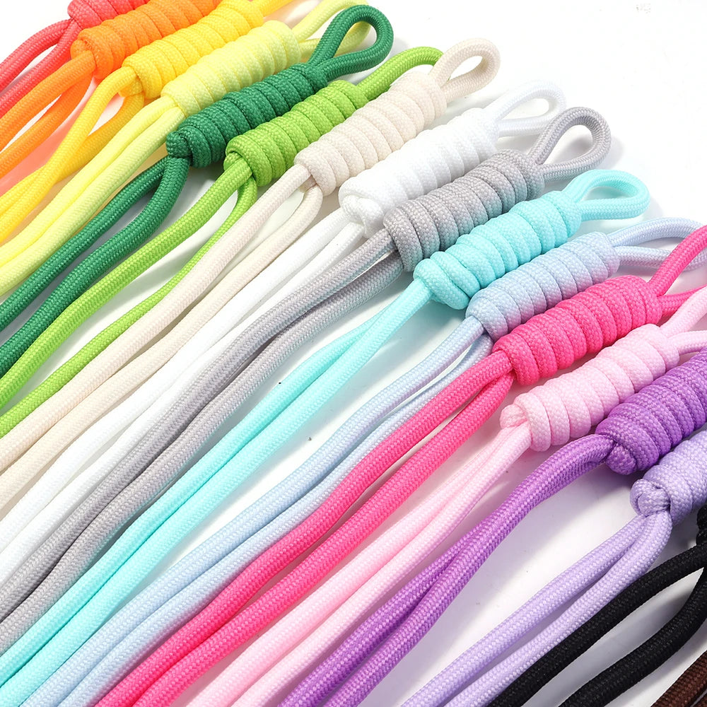 A variety of colorful braided nylon lanyards and keychains in shades of orange, yellow, green, white, blue, pink, and purple.