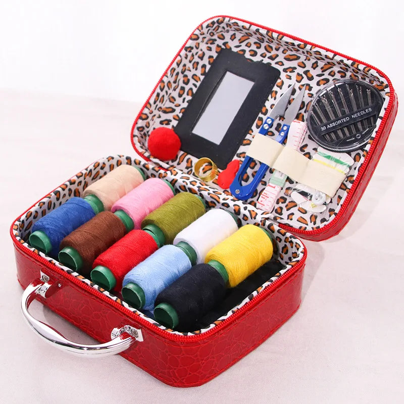 A red portable faux leather sewing kit box containing various colored threads and a needle organizer.