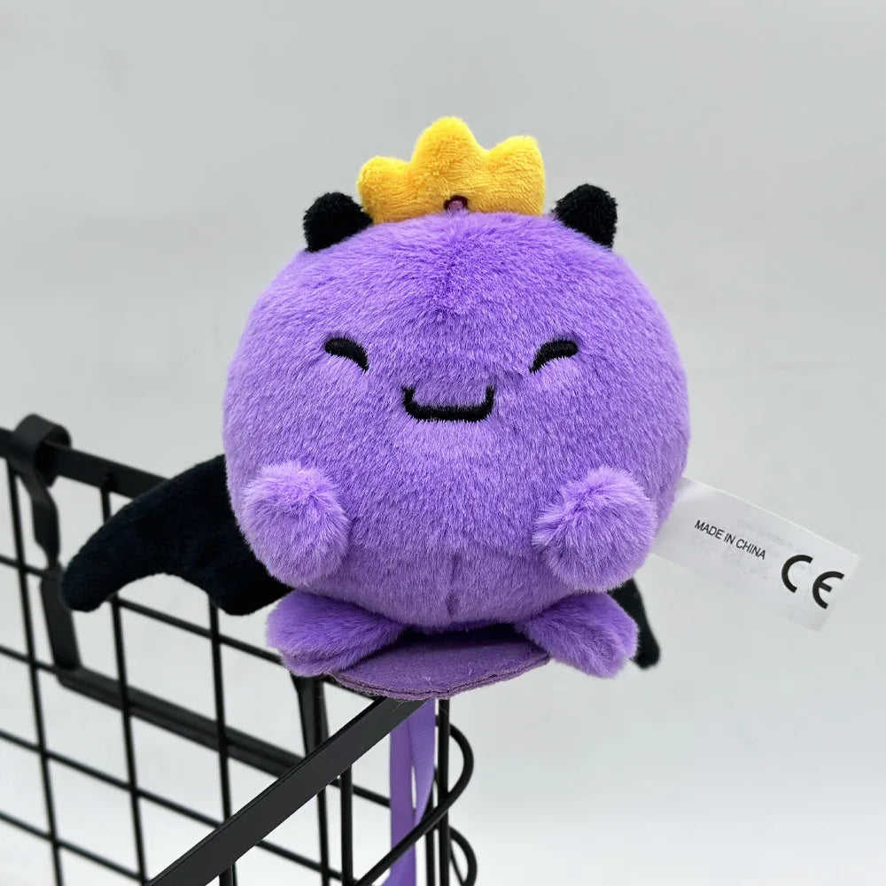 A cute purple plush doll with a yellow crown is displayed in a black wire basket.