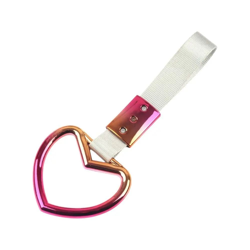 Heart-shaped car handle decor featuring a holographic finish and a white strap.
