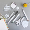 A set of six white vinyl weeding and craft tools, including a birthday sign and various precision tools, arranged on a gray s