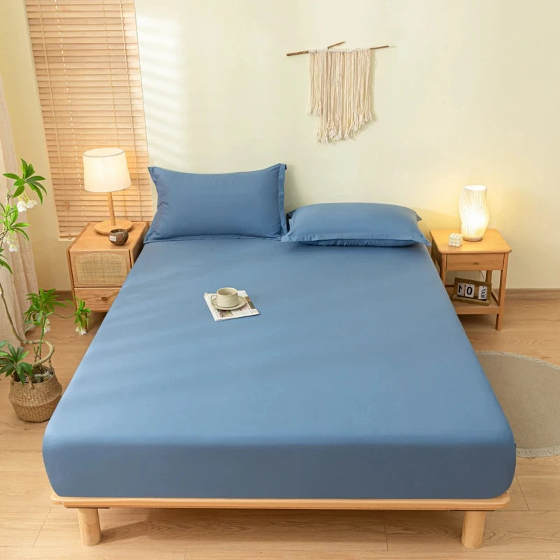 A light blue fitted bed sheet set with matching pillowcases on a wooden bed frame.