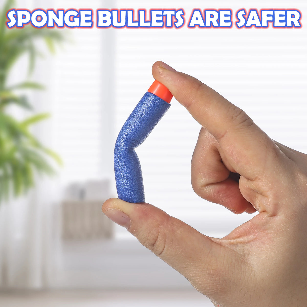 A hand holds a blue sponge bullet with an orange tip, demonstrating a safer alternative to traditional darts.