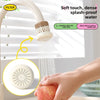 A hand is using a kitchen faucet sprayer with a filter to spray water onto a piece of fruit.