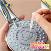 A hand is holding a shower cleaning brush set with an anti-clogging nozzle cleaner featuring numerous small cleaning bristles