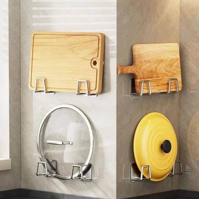 A set of stainless steel suction cup holders for sponges and dishcloths mounted on a wall.