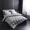 A quilted gray duvet with a white cotton cover displayed on a bed in a modern room.