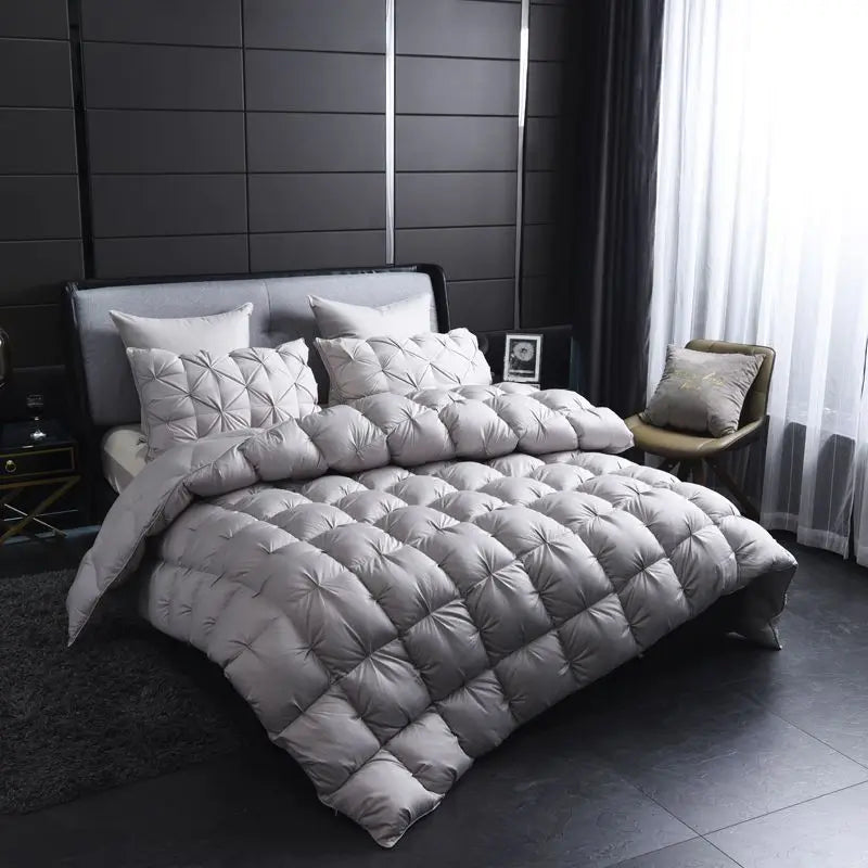 A quilted gray duvet with a white cotton cover displayed on a bed in a modern room.