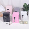 A collection of pink and silver vintage metal piggy banks with combination locks and keys displayed on a white surface.