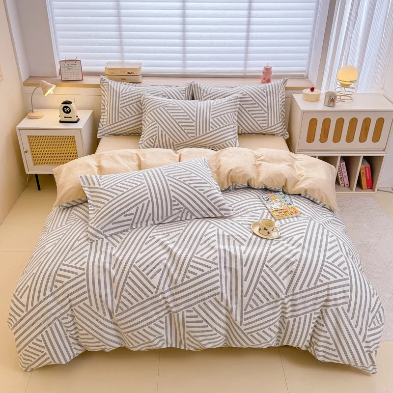 A beige and white striped duvet cover set with pillows displayed on a bed in a bright room.