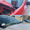Close-up of a red vehicle's fender showing black metal LED fog lamp mounting brackets installed on the front bumper.