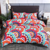 A vibrant floral and geometric patterned duvet cover set with matching pillowcases displayed on a bed.