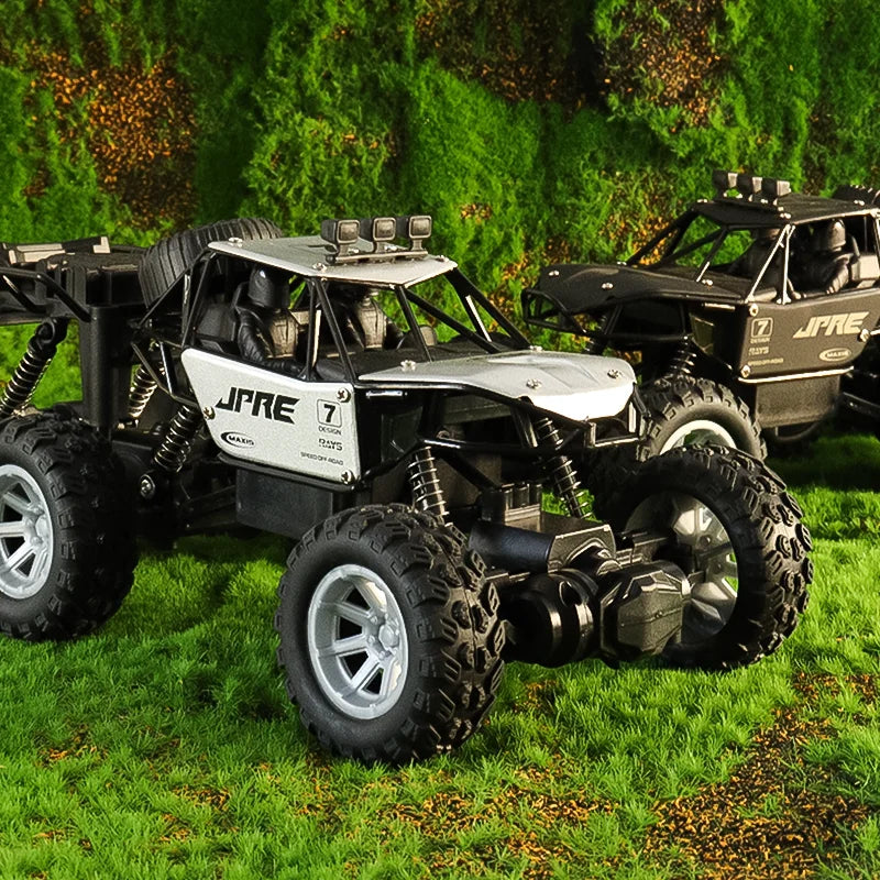 A black and white six-wheel drive off-road RC car with an alloy body parked on green grass.