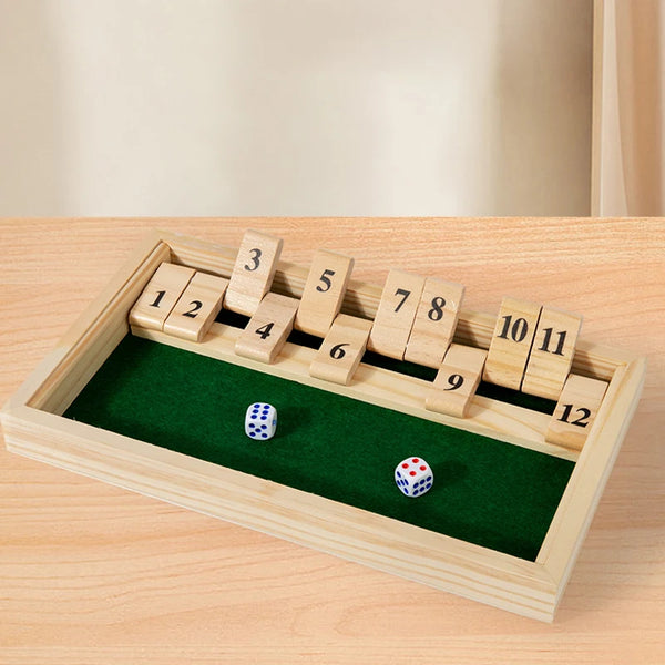Holzspiel mit nummerierten Blöcken und Würfeln auf grüner Filzoberfläche in Holzrahmen.