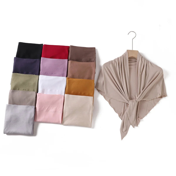 Eine Sammlung gefalteter Dreieck-Jersey-Hijabs in verschiedenen Farben und Schattierungen.