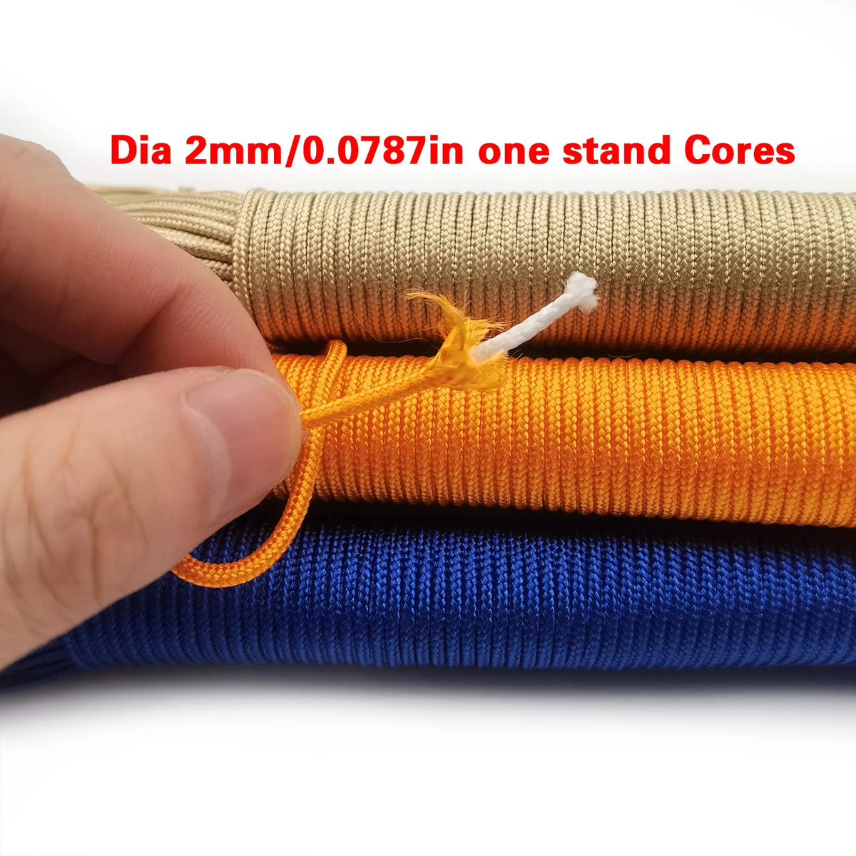 A hand is holding several strands of multi-color paracord, including beige, orange, and blue, showing the diameter.