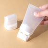 A hand holds a white wall paint repair roller with a refillable bottle and a separate white cleaning pad.