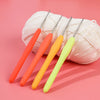 A set of four precision crochet hooks in orange, yellow, and lime green are displayed on a pink background.