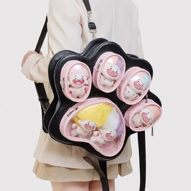 A black backpack with pink accents and multiple clear pockets shaped like cat paw prints.