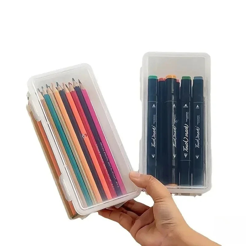 A hand holds a clear storage box containing several colored pencils and pens.