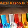 A collection of colorful metal kazoo flutes, including silver aluminum and various colored plastic ones.