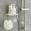 A wall-mounted soap dish with drainage featuring a white bottle and a decorative white pom-pom.