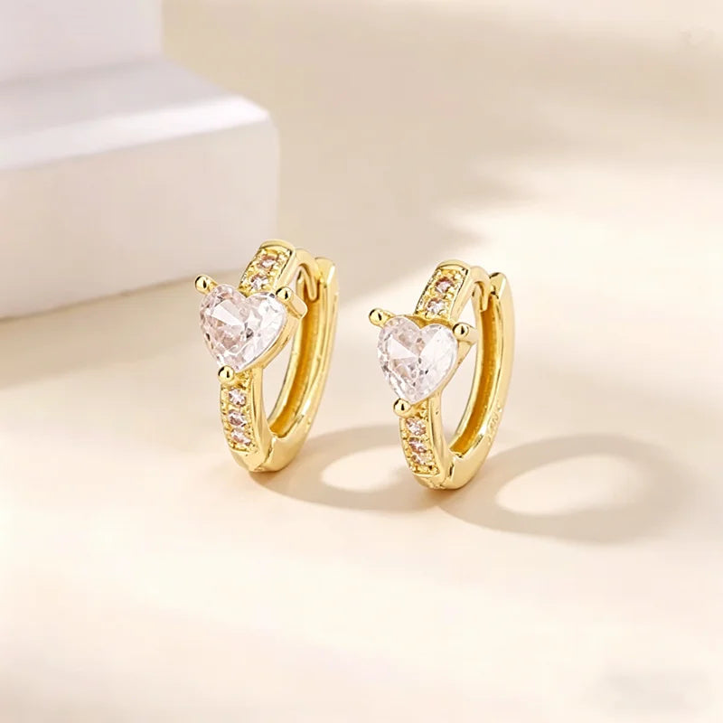 Par de aretes de aro dorados con una piedra de circonita sintética en forma de corazón.