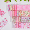 A collection of pink cotton quilted fabric strips featuring various floral and polka dot patterns for DIY crafting.