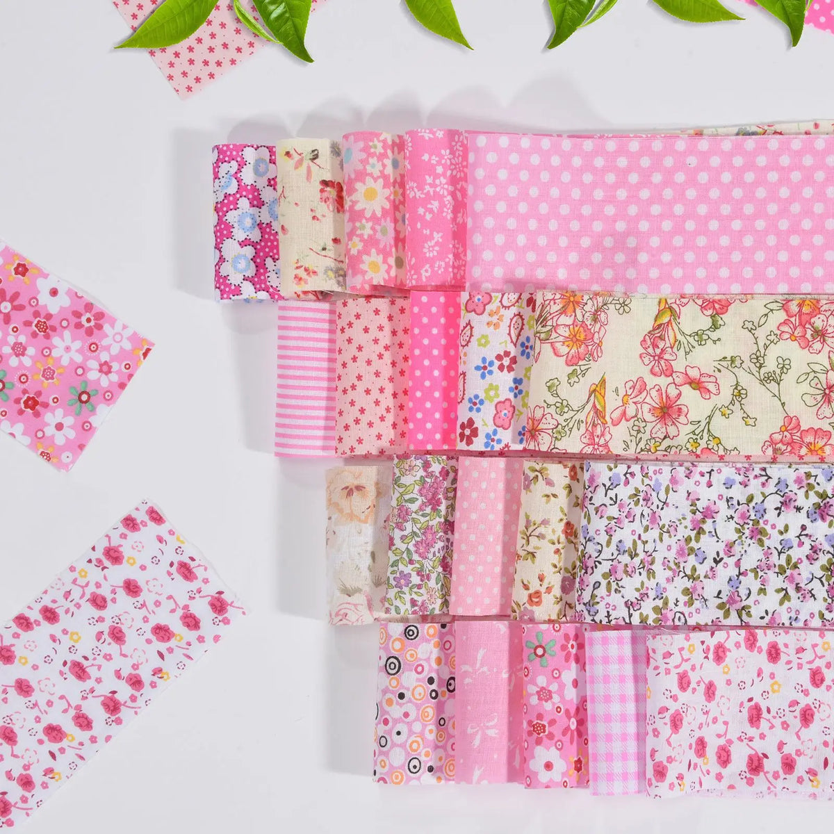 A collection of pink cotton quilted fabric strips featuring various floral and polka dot patterns for DIY crafting.