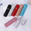 A collection of ten colorful 10ml refillable glass perfume atomizers in various shades and finishes displayed on a white tray
