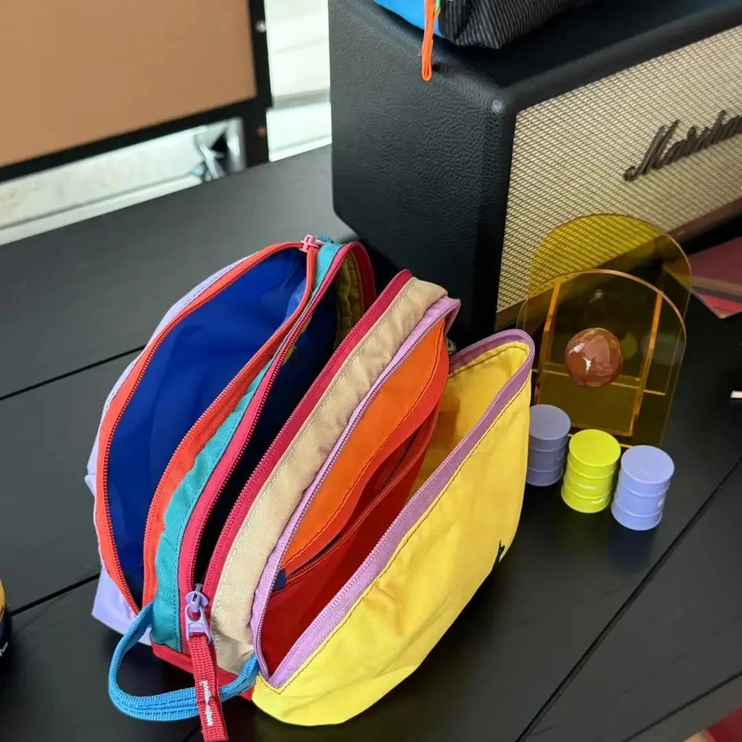 Eine Sammlung leichter Reise-Toilettentaschen in verschiedenen Dopaminfarben, darunter Blau, Orange, Pink und Gelb.