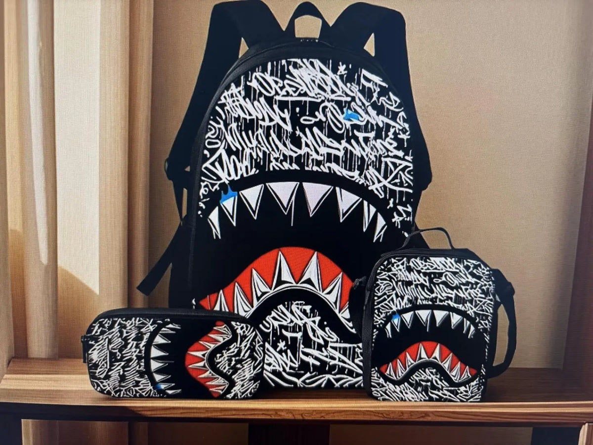 A set of black backpacks featuring a graphic print of a shark's open mouth and teeth.