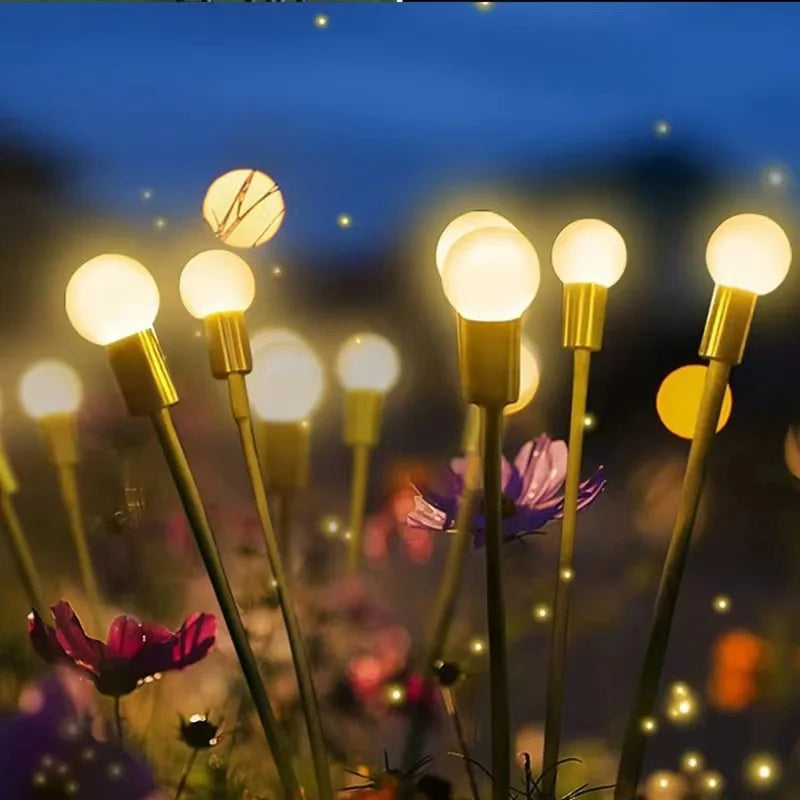 Nahaufnahme von solarbetriebenen Glühwürmchen-Gartenlichtern, die eine dunkle Außenansicht mit leuchtenden Glühbirnen und lil